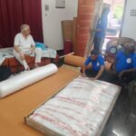 Mahalaxmi Packers and Movers crew in uniform packing furniture with bubble wrap and corrugated sheets at a customer home during house shifting in Madurai
